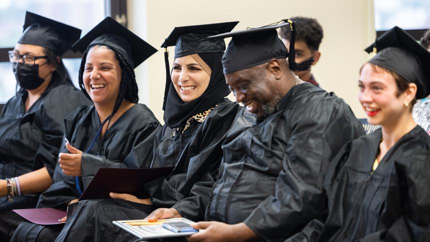 HiSET graduates sitting together dressed in caps and gowns