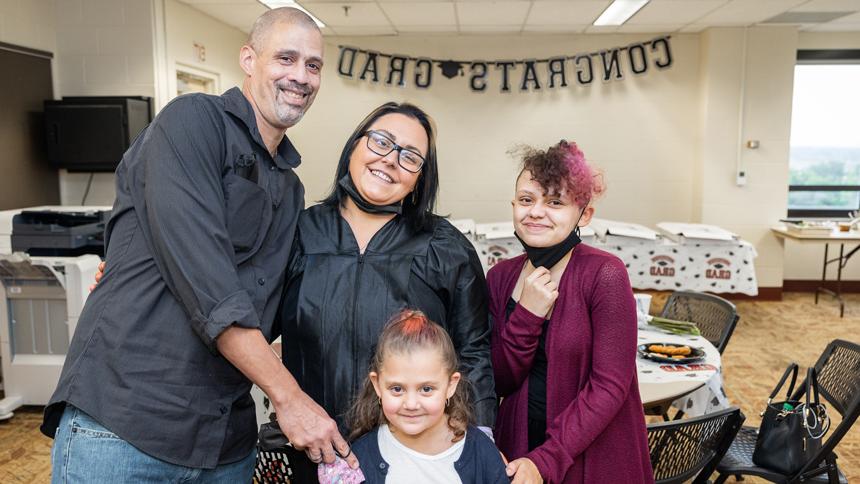 HiSET graduate with family of husband and two young girls